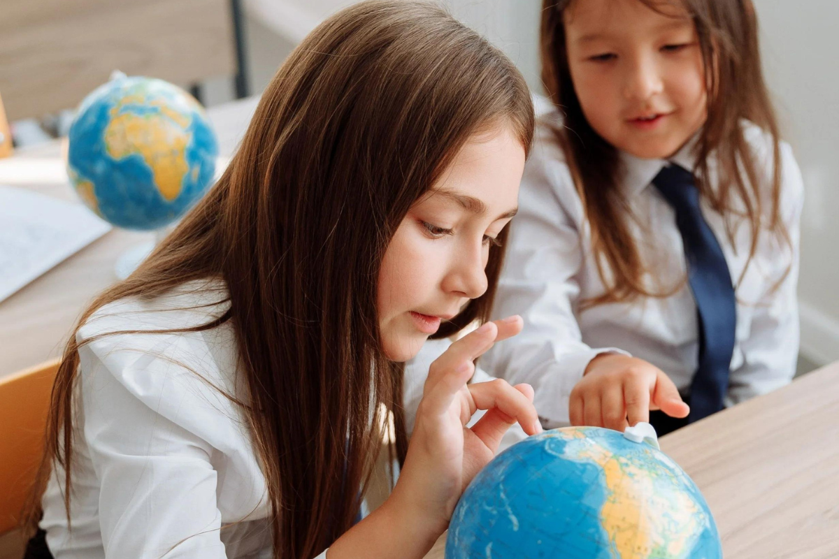 Two girls looking at a globe