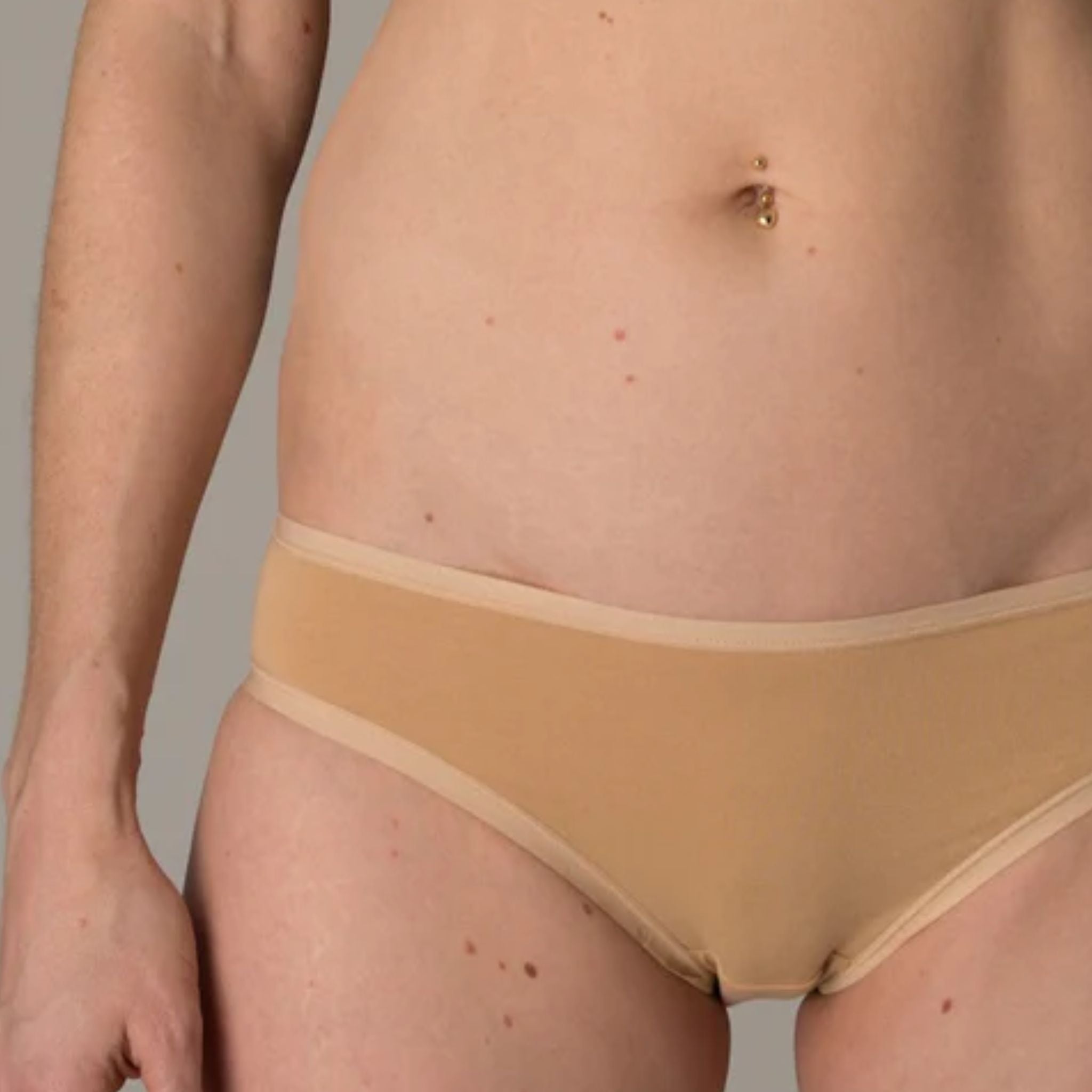 Person wearing almond bikini bottoms, showing front view
